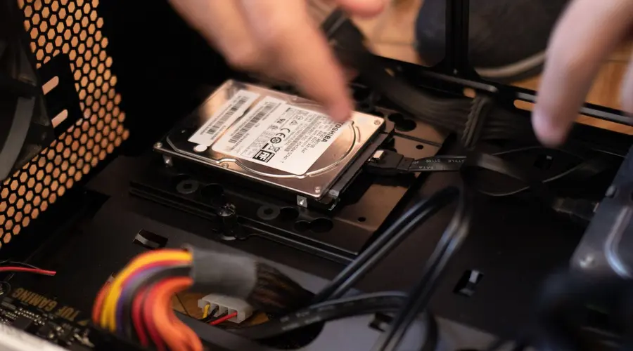 Technician installing a storage drive inside a desktop computer
